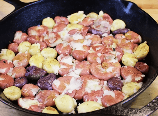 Cast iron pan of smashed potatoes